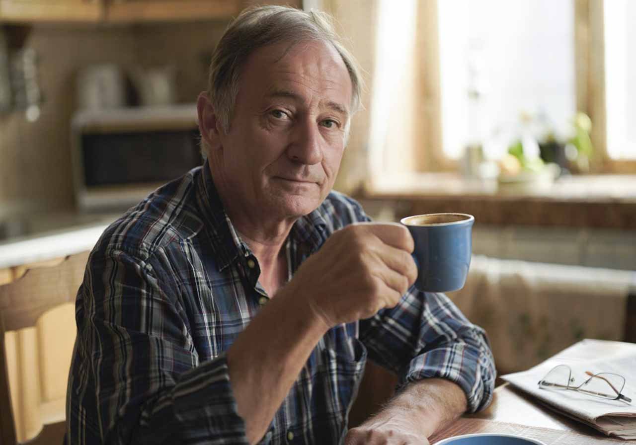 Пожилой мужчина пьет чай